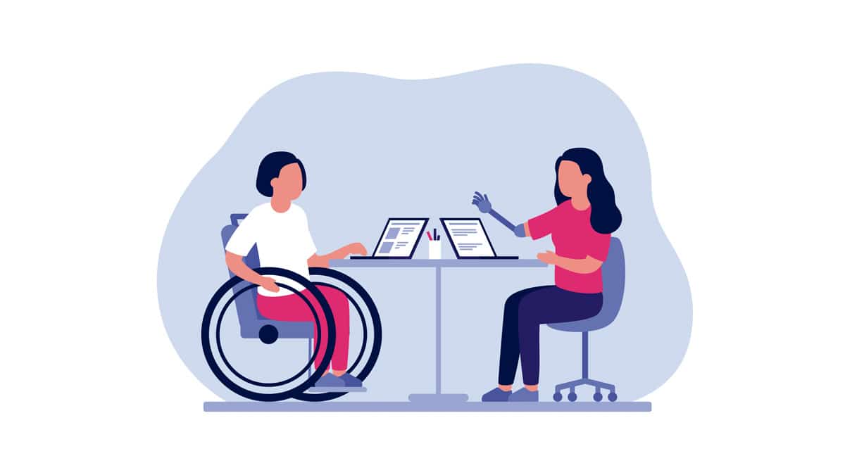 uma mulher em uma cadeira de rodas e outra mulher com uma prótese de braço sentadas à mesa